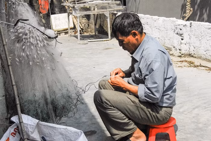 Ngư dân xã Đồng Tiến (huyện Cô Tô) đan, vá lưới chuẩn bị ra khơi đánh cá.