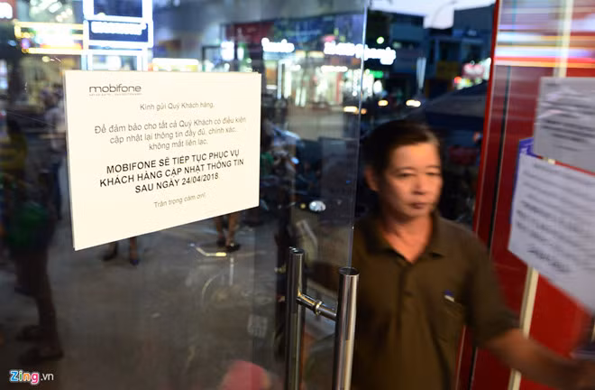 Thông báo dán trước cửa một điểm đăng ký thông tin thuê bao của MobiFone. Ảnh: Lê Quân.