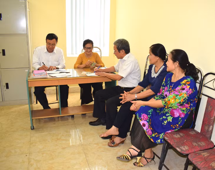 Ông Trương Công Thành (ngoài cùng bên trái) trong một buổi thanh toán chế độ cho NCT tại phường Quang Hanh (Cẩm Phả)