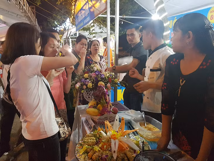 Thực khách nếm thử thức ăn được bày bán bên đường.