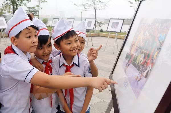 Các em học sinh xem Triển lãm ảnh. (Ảnh: Trung Kiên/TTXVN)