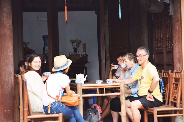 Khách du lịch tham quan nhà gỗ 180 năm tuổi của gia đình bà Nguyễn Thị Dương, thôn Đồng Sơn, xã Yên Đức, TX Đông Triều.