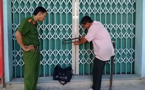 Công an dùng cưa phá kháo giải cứu gia đình bà Quy bị côn đồ khoá cửa nhốt trong nhà.