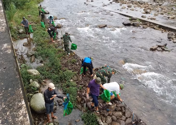 Cán bộ, chiến sĩ Đồn Biên phòng Pò Hèn và nhân dân thôn Pò Hèn, xã Hải Sơn tham gia dọn vệ sinh suối biên giới.
