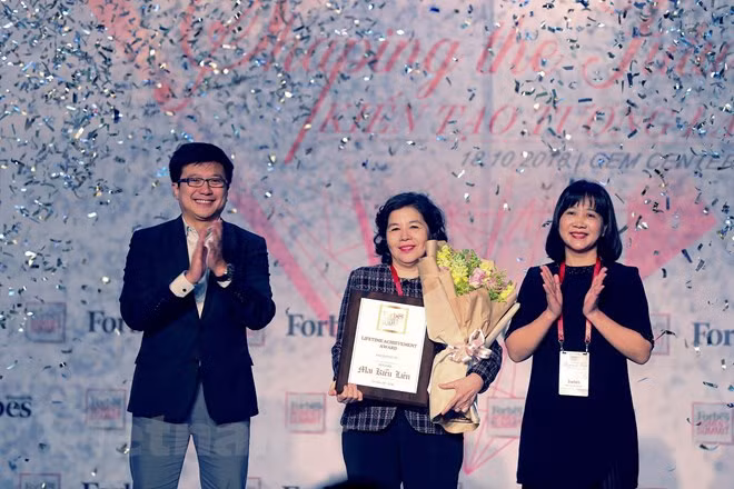 Ông Nguyễn Bảo Hoàng – Chủ tịch Công ty Truyền thông Tương tác, Forbes Việt Nam và bà Chu Thị Thu Hằng, Tổng biên tập báo Văn hóa trao giải thưởng “Thành tựu trọn đời” cho bà Mai Kiều Liên – Tổng Giám đốc Vinamilk. (Ảnh: Lý Võ Phú Hưng/Vietnam+)