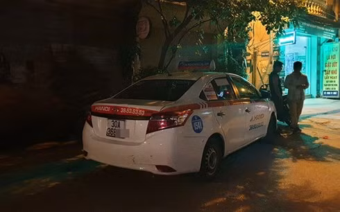 Chiếc xe taxi của nạn nhân tại hiện trường.