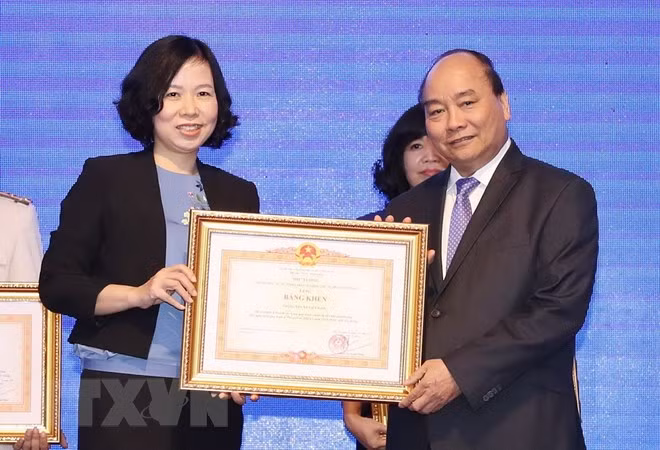 Thủ tướng Nguyễn Xuân Phúc trao tặng Bằng khen của Thủ tướng Chính phủ cho Thông tấn xã Việt Nam vì thành tích xuất sắc tại WEF ASEAN 2018. (Ảnh: Thống Nhất/TTXVN