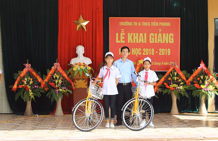 Ông Nguyễn Phúc Phong, Giám đốc Quỹ Bảo trợ trẻ em Quảng Ninh, trao xe đạp cho trẻ em có hoàn cảnh khó khăn nhân dịp khai giảng năm học 2018-2019 tại Trường Tiểu học và THCS Tiền Phong, TX Quảng Yên.