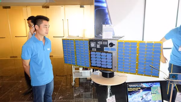 Các kỹ sư phát triển bên cạnh mô hình tỷ lệ 1:1 của vệ tinh MicroDragon. Ảnh: Trọng Đạt
