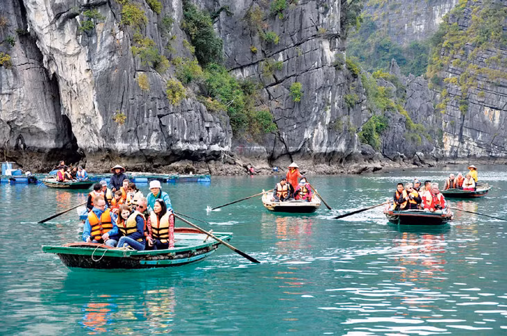 Khách du lịch đi thuyền nan tham quan Vịnh Hạ Long. Ảnh: Thu Nguyên