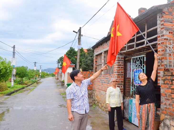 Người dân thôn Đoàn Xá 2, xã Hồng Phong treo cờ tổ quốc chào mừng ngày bầu cử. 