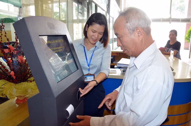 Cán bộ TTHCC tỉnh hướng dẫn công dân lấy số thứ tự để giải quyết thủ tục hành chính.