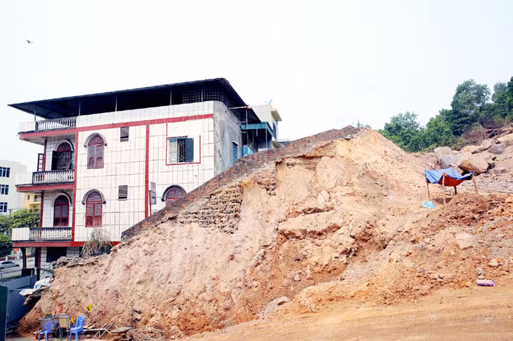 Nhà thầu thi công dự án Khu dân cư đồi Ngân hàng đã đào đất đến sát nhà dân, lấn sâu chân kè, tạo thành bức tường đất chênh vênh.