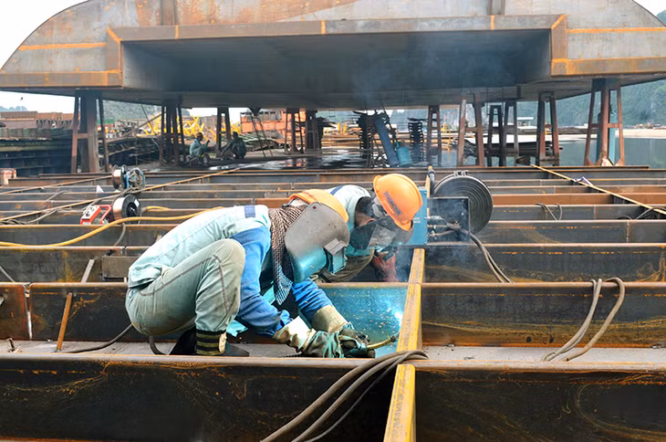 Các học viên lớp sơ cấp hàn được nhận vào Công ty CP Công nghiệp tàu thuỷ Đông Bắc làm việc ngay sau khi kết thúc khoá học. Trong ảnh: Công nhân đang hàn các chi tiết trong đóng mới sà lan.