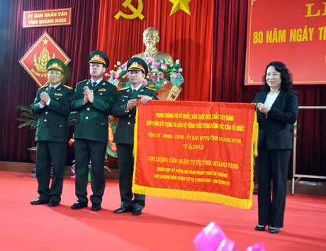 Đồng chí Vũ Thị Thu Thủy, Phó Chủ tịch UBND tỉnh trao bức trướng của Tỉnh uỷ, HĐND, UBND, UBMTTQ tỉnh cho lực lượng DQTV tỉnh.