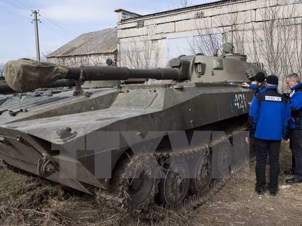 Các thành viên Phái bộ giám sát đặc biệt của Tổ chức An ninh và Hợp tác châu Âu (OSCE) tại Ukraine kiểm tra xe bọc thép của lực lượng ly khai Cộng hòa Nhân dân Donetsk tự xưng. (Nguồn: AFP/TTXVN)