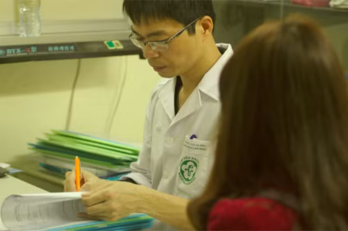 Bác sĩ Nguyễn Hữu Trường, Trung tâm dự ứng miễn dịch lâm sàng, Bệnh viện Bạch Mai, đang kê đơn thuốc cho một bệnh nhân lupus ban đỏ. Ảnh: MT.