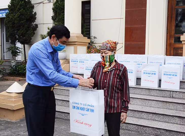 Lãnh đạo Công ty CP Cụm công nghiệp Cẩm Thịnh trao tặng quà cho hộ nghèo phường Cẩm Thịnh.