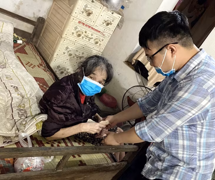 Cán bộ Phòng LĐ-TB&XH huyện Tiên Yên chi trả phụ cấp tận ứng trước 2 tháng cho bà cụ Nguyễn Thị Liễu 100 tuổi ở phố Thống Nhất, thị trấn Tiên Yên, ngày 16/4 