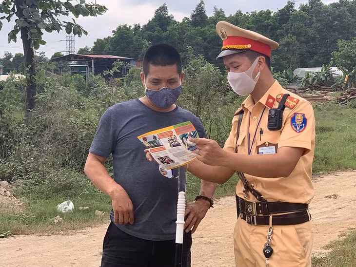 Thượng úy Lê Quốc Vinh, cán bộ Đội CSGT số 2, Phòng CSGT đường bộ, đường sắt Công an tỉnh Quảng Ninh tuyên truyền Luật Giao thông trực tiếp cho người dân tại hiện trường