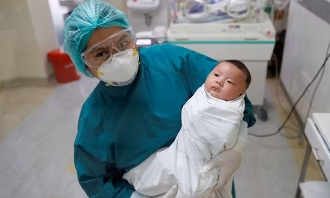 Y tá tại Viện các Bệnh truyền nhiễm Bamrasnaradura ở Bangkok bế em bé một tháng tuổi đã chiến thắng Covid-19, vào hôm qua, một ngày trước khi em xuất viện. Ảnh: Reuters.