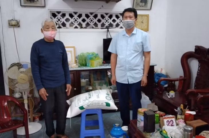 Đồng chí Vũ Trung Chính, Bí thư Đảng ủy, Chủ tịch UBND phường Hòa Lạc (TP Móng Cái) trao gạo cho gia đình người cao tuổi.