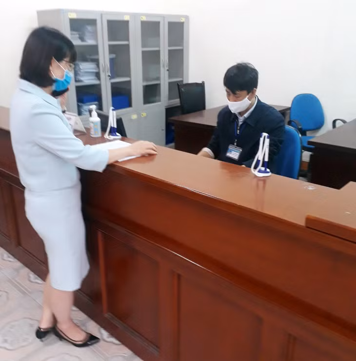 Cán bộ Chi cục Thuế Cẩm Phả - Vân Đồn – Cô Tô hướng dẫn người dân đến làm thủ tục nộp thuế. Ảnh chụp ngày 13/4