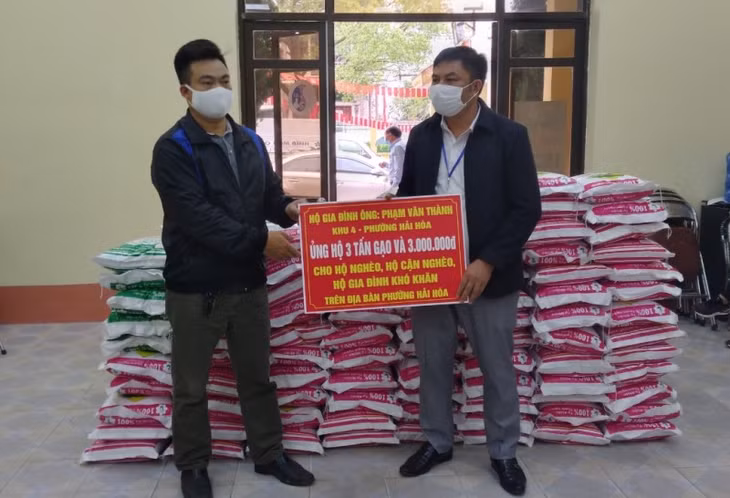 Thợ cắt tóc Phạm Văn Thành (bên trái) ủng hộ gạo chống dịch.