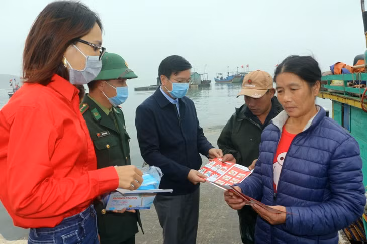 Cán bộ Đồn Biên phòng Thanh Lân phối hợp cùng các lực lượng tuyên truyền ngư dân phòng chống Covid-19.