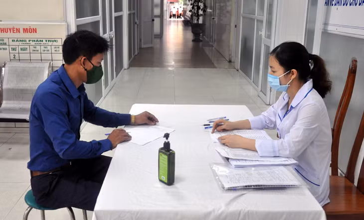 Lực lượng chức năng hướng dẫn công nhân Công ty Than Mạo Khê – TKV điền phiếu thu thập thôn tin trước khi lấy mẫu xét nghiệm.