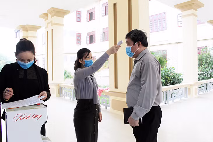 Các đại biểu được kiểm tra thân nhiệt, đảm bảo an toàn phòng chống dich Covid-19 trước khi vào dự hội nghị