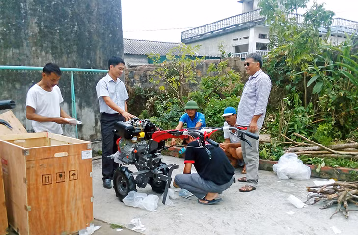 Kỹ sư Nguyễn Văn Phú (đứng giữa) hướng dẫn cách sử dụng máy làm đất cho các hộ dân trồng cam tại thôn Tân Lương, xã Tân Bình, huyện Đầm Hà.