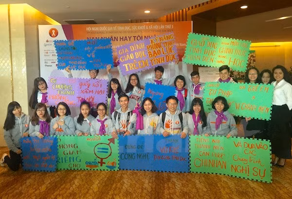 Các bạn sinh viên với những khẩu hiệu, thông điệp tại hội nghị quốc gia về tình dục, sức khỏe và xã hội. (Ảnh: PV/Vietnam+)