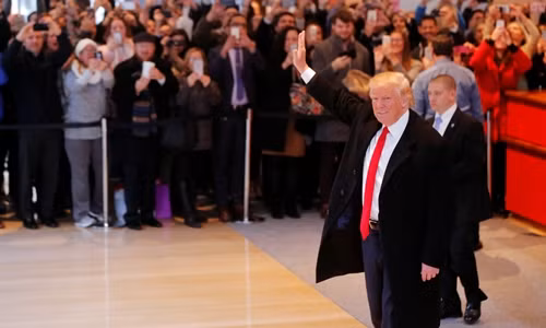 Donald Trump chào đám đông tập trung ở sảnh tòa nhà của New York Times ngày 22/11. Ảnh: Reuters