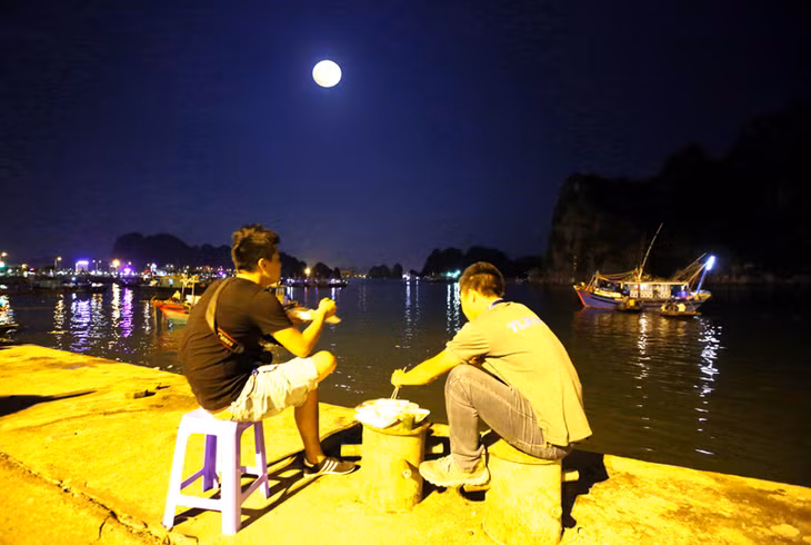 Hai vị khách du lịch “bụi” vừa ẩm thực vừa ngắm trăng Hạ Long.