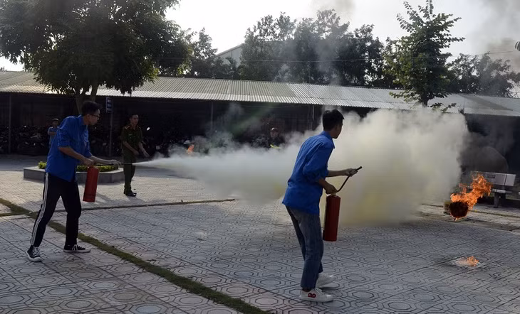 Thức tập dùng bình chữa cháy dập tắt lửa khay xăng.