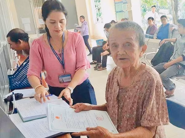 82 tuổi, lần đầu tiên bà Nữ được cầm giấy khai sinh của mình trên tay. Ảnh: N.H.
