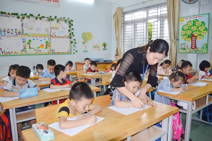 Cô giáo Trần Thị Thu Hằng uốn nắn cách cầm bút, tư thế ngồi đúng cho học sinh.