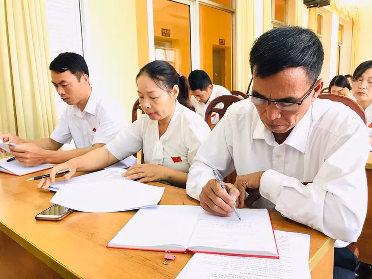 Đại biểu xã Dân Chủ, huyện Hoành Bồ ghi chép thông tin tại kỳ họp. 