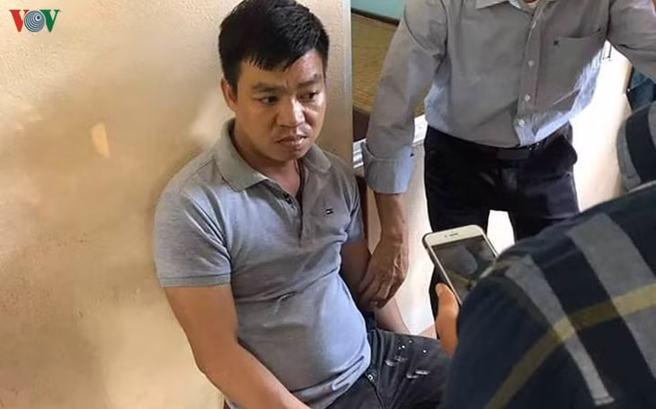 Đối tượng (mặc áo thun ngồi ghế) bị nhà trường bắt giữ.