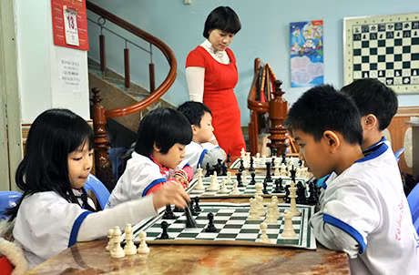 Chị Phạm Thu Trang, Chủ nhiệm CLB Cờ vua Thông Minh đang hướng dẫn các em học sinh chơi cờ.