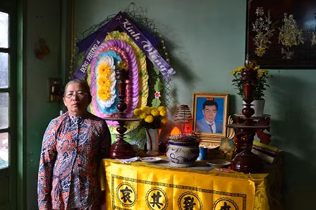 Bà mẹ D bên bàn thờ tang người chồng xấu số bị liệt 4 năm trước khi qua đời.