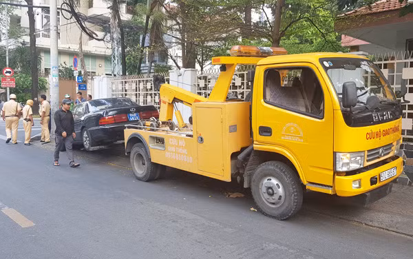 Lực lượng chức năng dùng phương tiện cẩu chiếc ô tô về trụ sở để xác minh làm rõ. (Ảnh: CN)