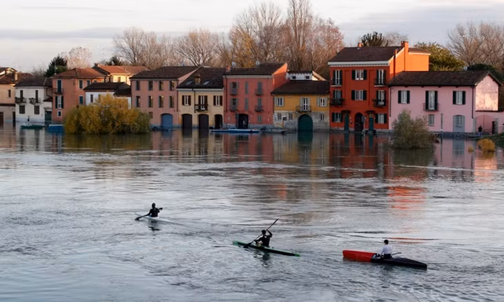 Người dân chèo thuyền về nhà sau khi sông Ticino tại Pavia, Italy tràn bờ hôm 25/11. Ảnh: AP.