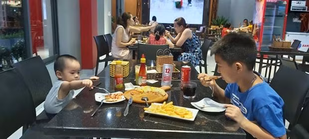 Khách hàng thưởng thức ẩm thực tại cửa hàng Pizza Happy, TP Hạ Long.