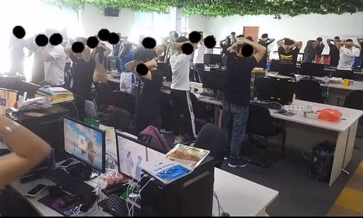 Các nghi phạm vòng hai tay sau đầu khi bị cảnh sát đột kích vào trụ sở ở Cyberjaya, bang Selangor, Malaysia hôm 20/11. Ảnh: Immigrationmalaysia/ Facebook. 