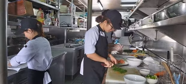 Chế biến đồ ăn cho du khách tại một du thuyền của Công ty CP du thuyền 5 sao Tuần Châu.