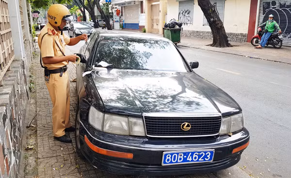 Cảnh sát giao thông niêm phong chiếc xe để đưa về trụ sở xử lý. (Ảnh: CN)
