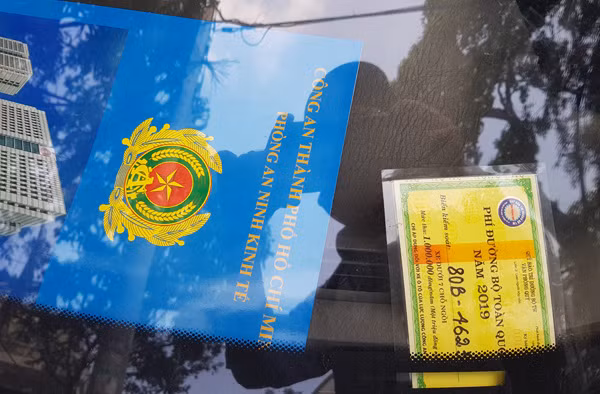 Phiếu “Phí đường bộ toàn quốc năm 2019” và bìa giấy kẹp tài liệu bên trong chiếc xe. (Ảnh: CN)