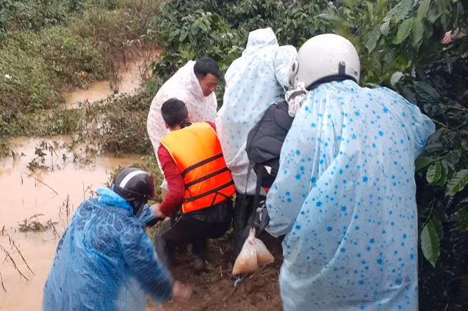 Lực lượng cứu hộ đưa hai nạn nhân bám được vào cây rừng vào bờ. Ảnh: Khánh Hương.